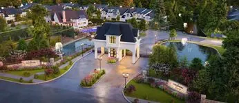 Aerial view of a gated residential community entrance with a white security building.