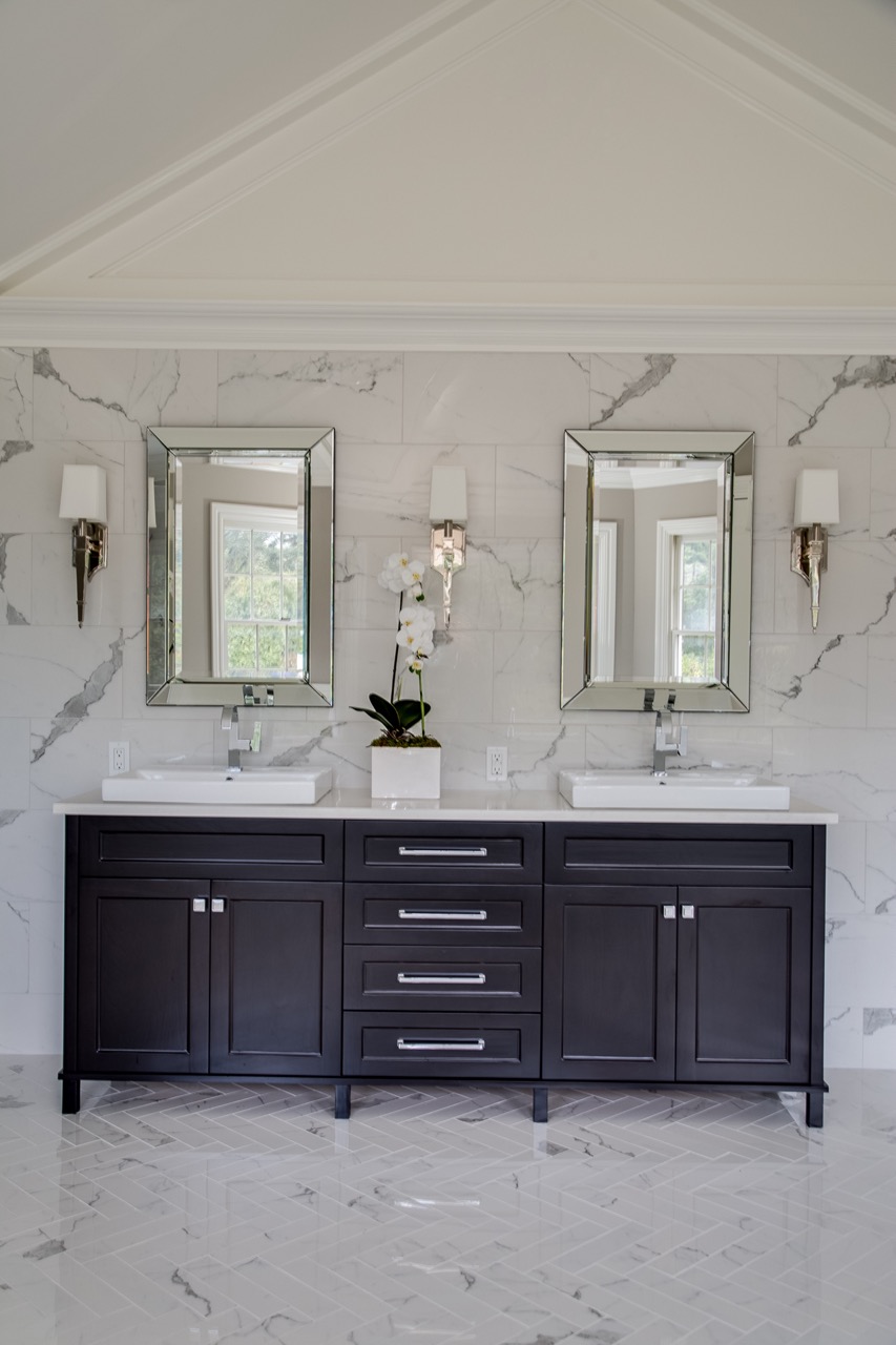 marble wall bathroom with double mirrors and dark brown vanity