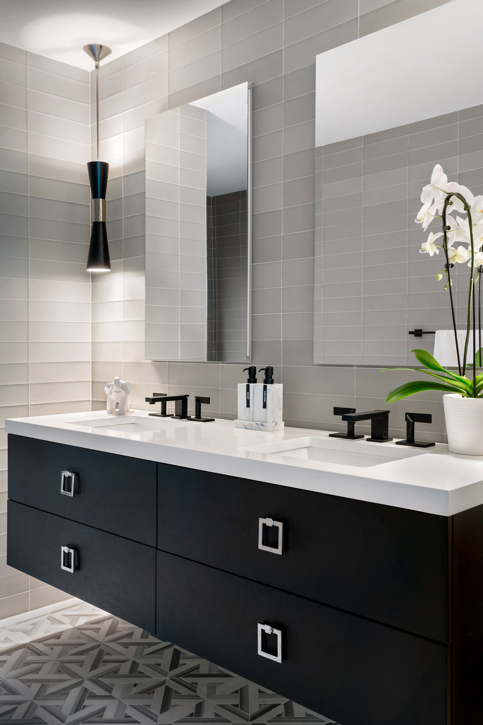 large white tiles on walls in bathroom with dark floating double vanity and double mirrors