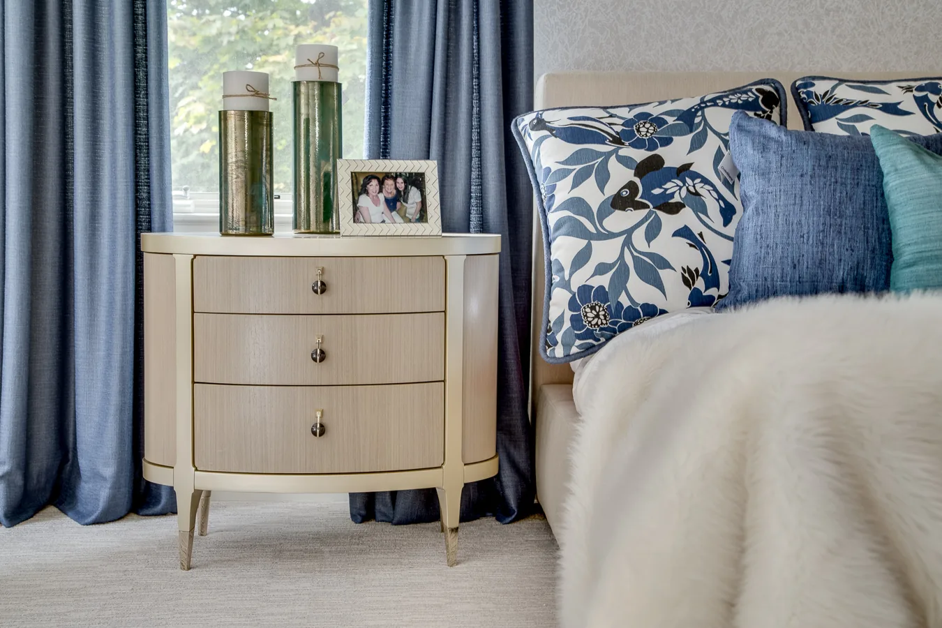 coastal chic style bedroom with beige bedding, floor and walls with blue accent pillows and curtains