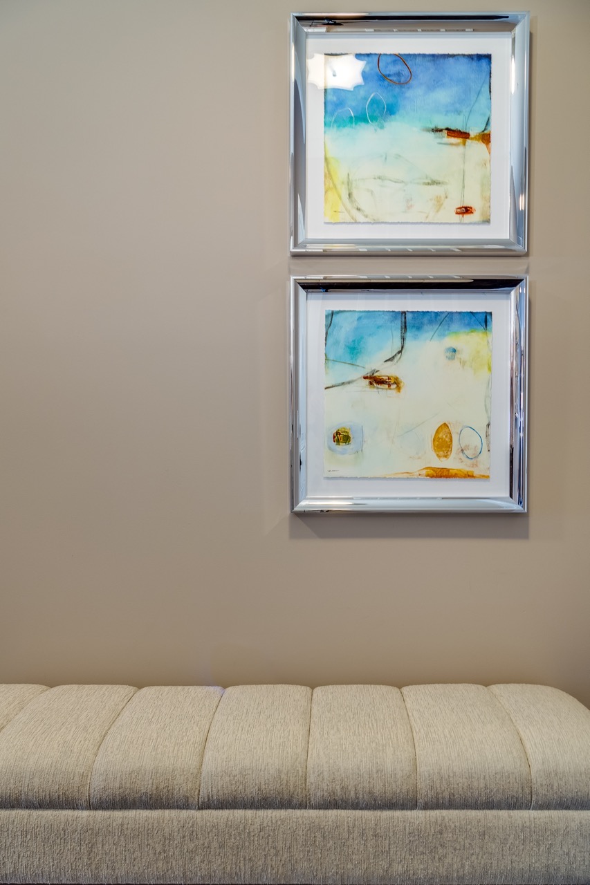 entranceway bench in tan with colorful beachy images on the wall
